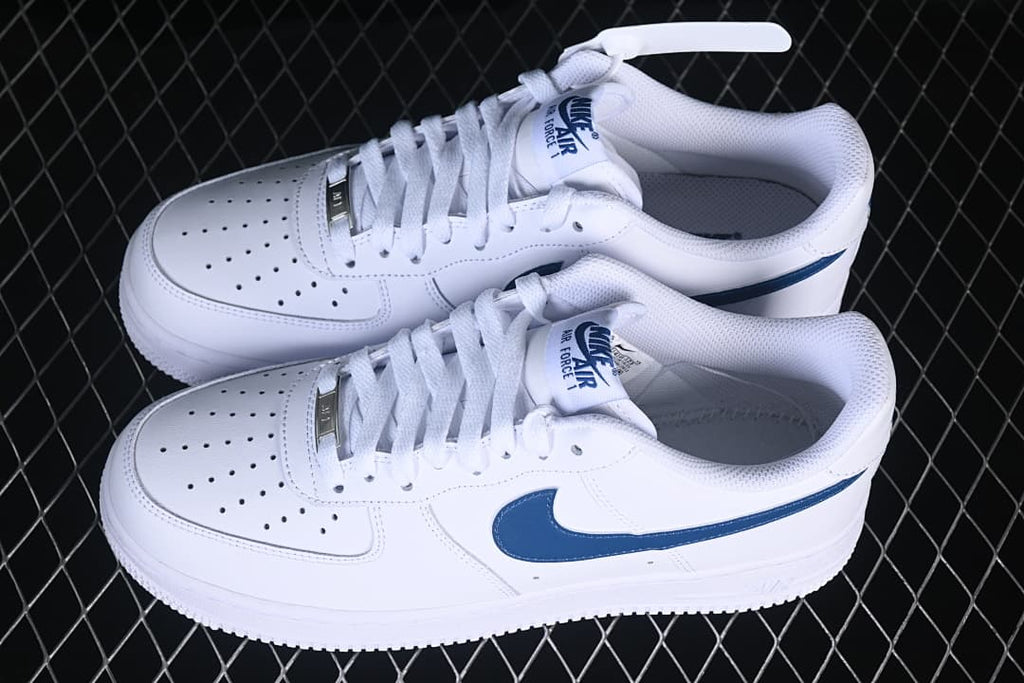 Pair of white and navy Nike Air Force 1 ’07 Low sneakers viewed from above