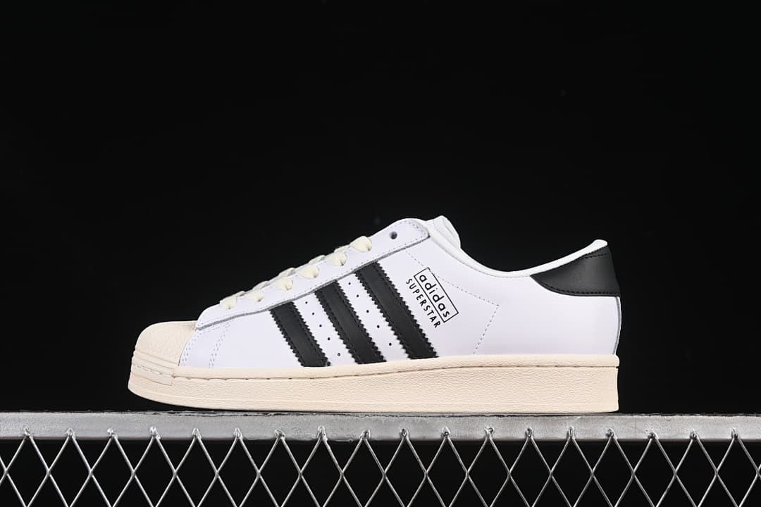 Adidas Superstar low-top sneaker in white and black with a cream outsole, side view