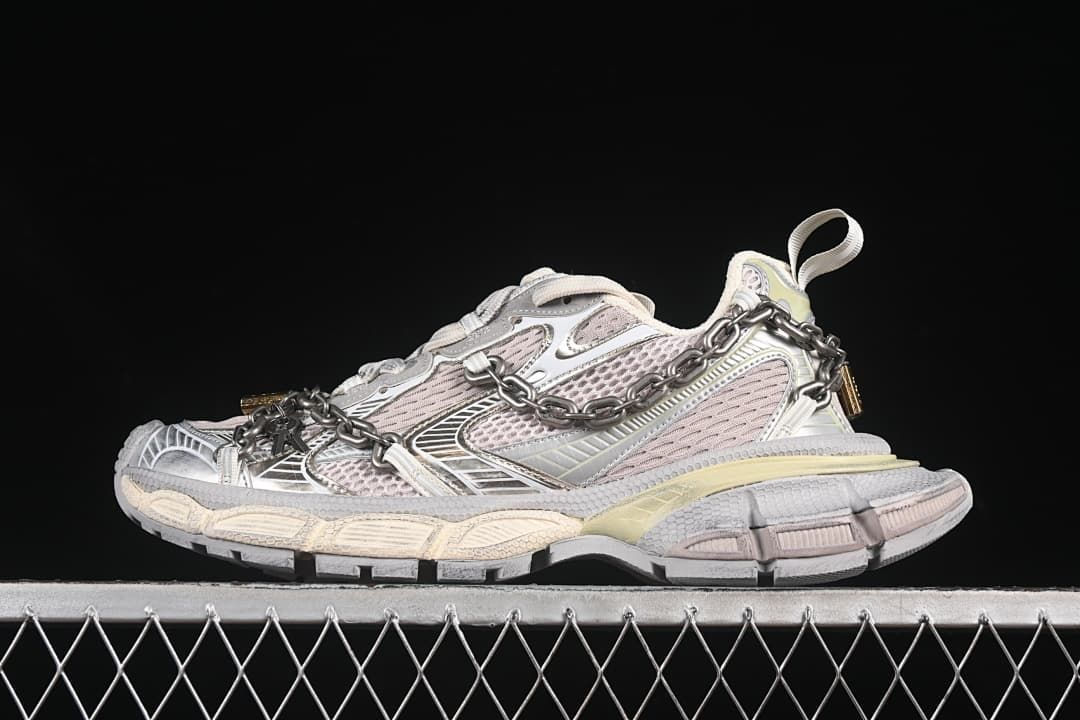 Side view of the silver, grey, and pale pink sneaker with decorative chain.