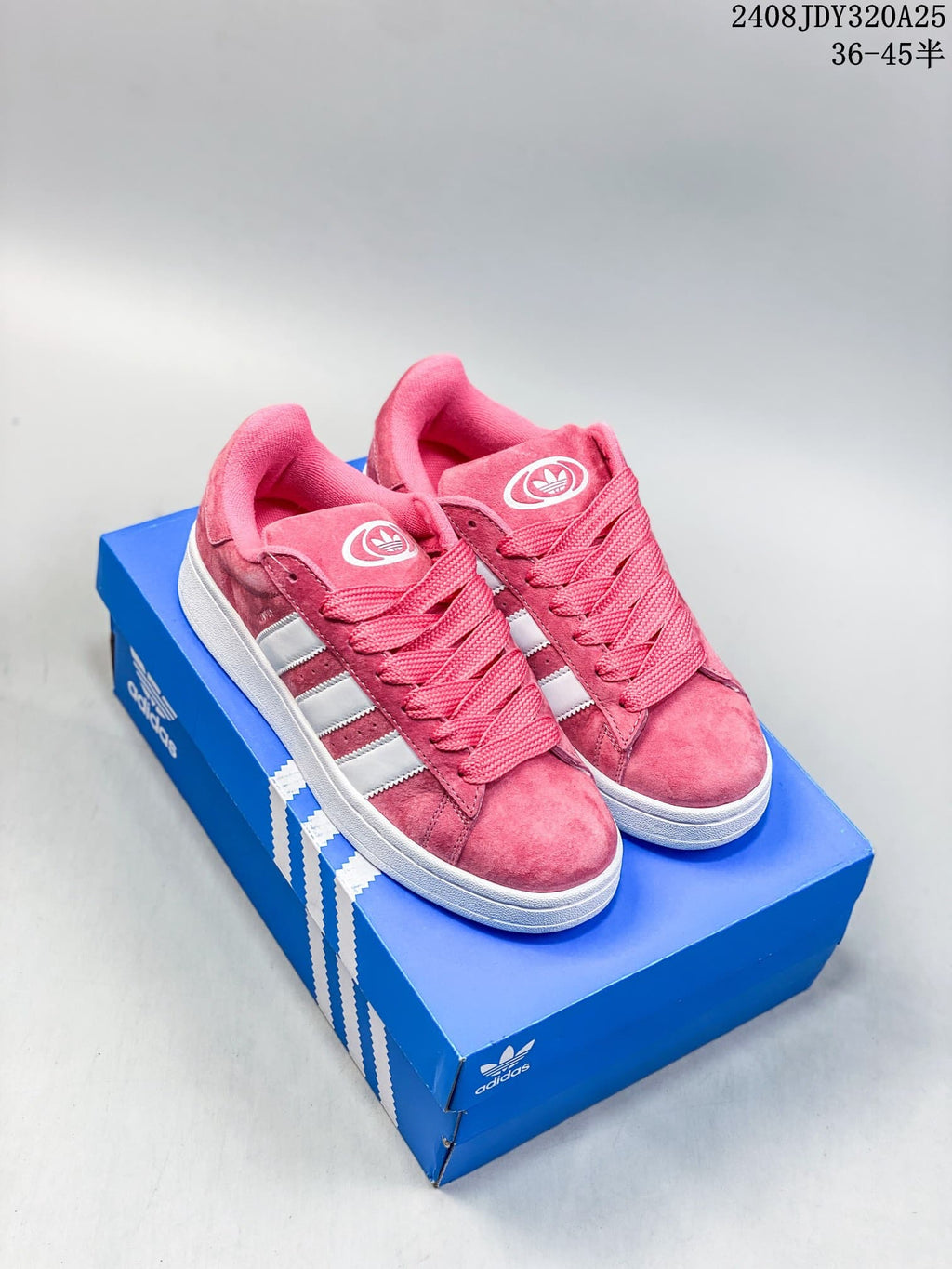Pink adidas Campus-style low-top sneakers with white stripes on a blue shoe box.