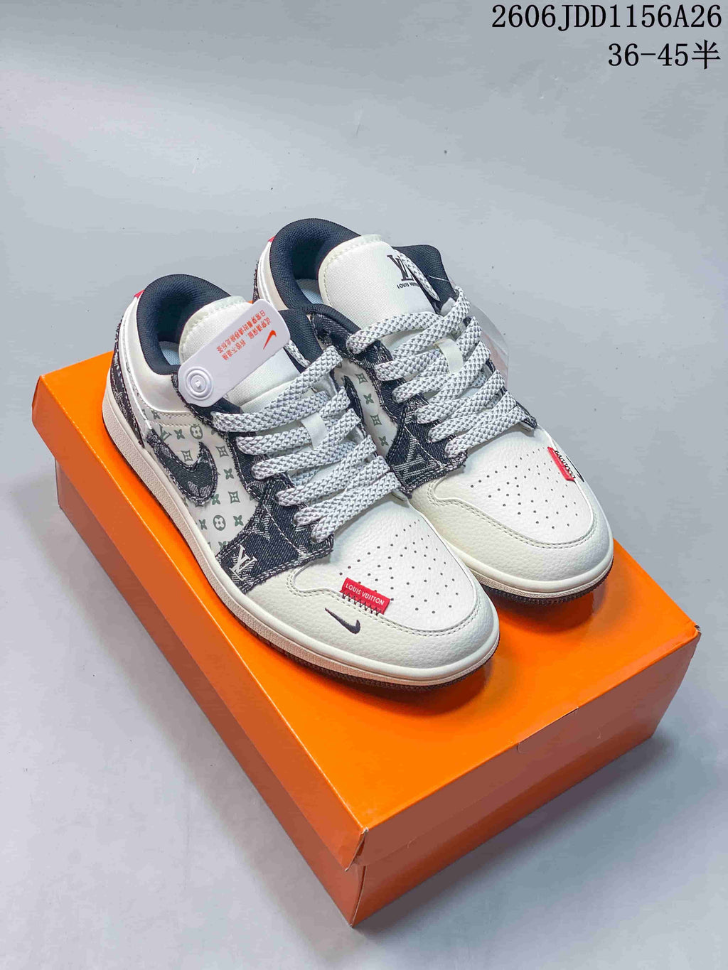 Pair of white low-top sneakers with dark patterned overlays and red accent tabs.