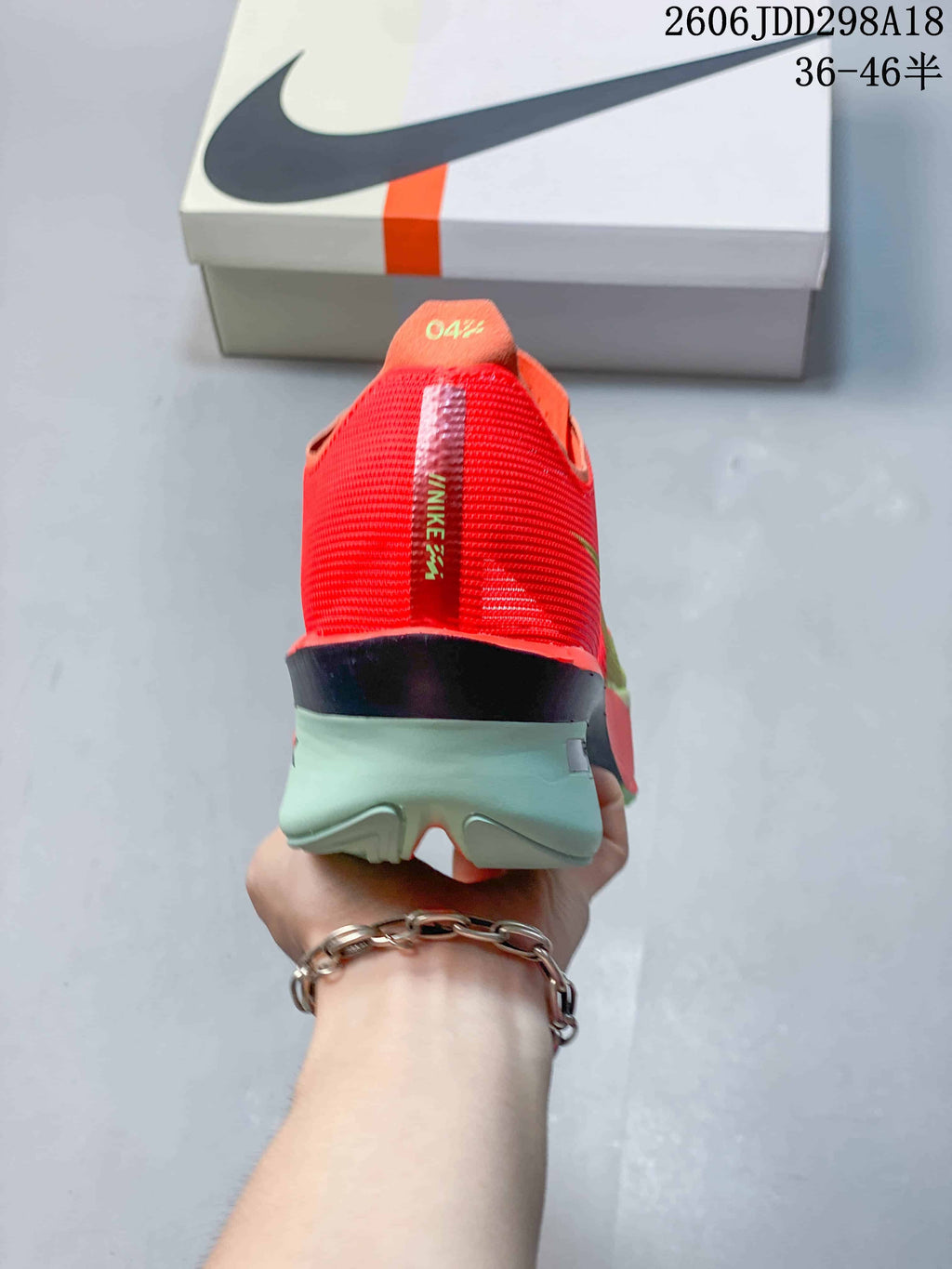 Rear view showing the red heel and sculpted mint-colored midsole