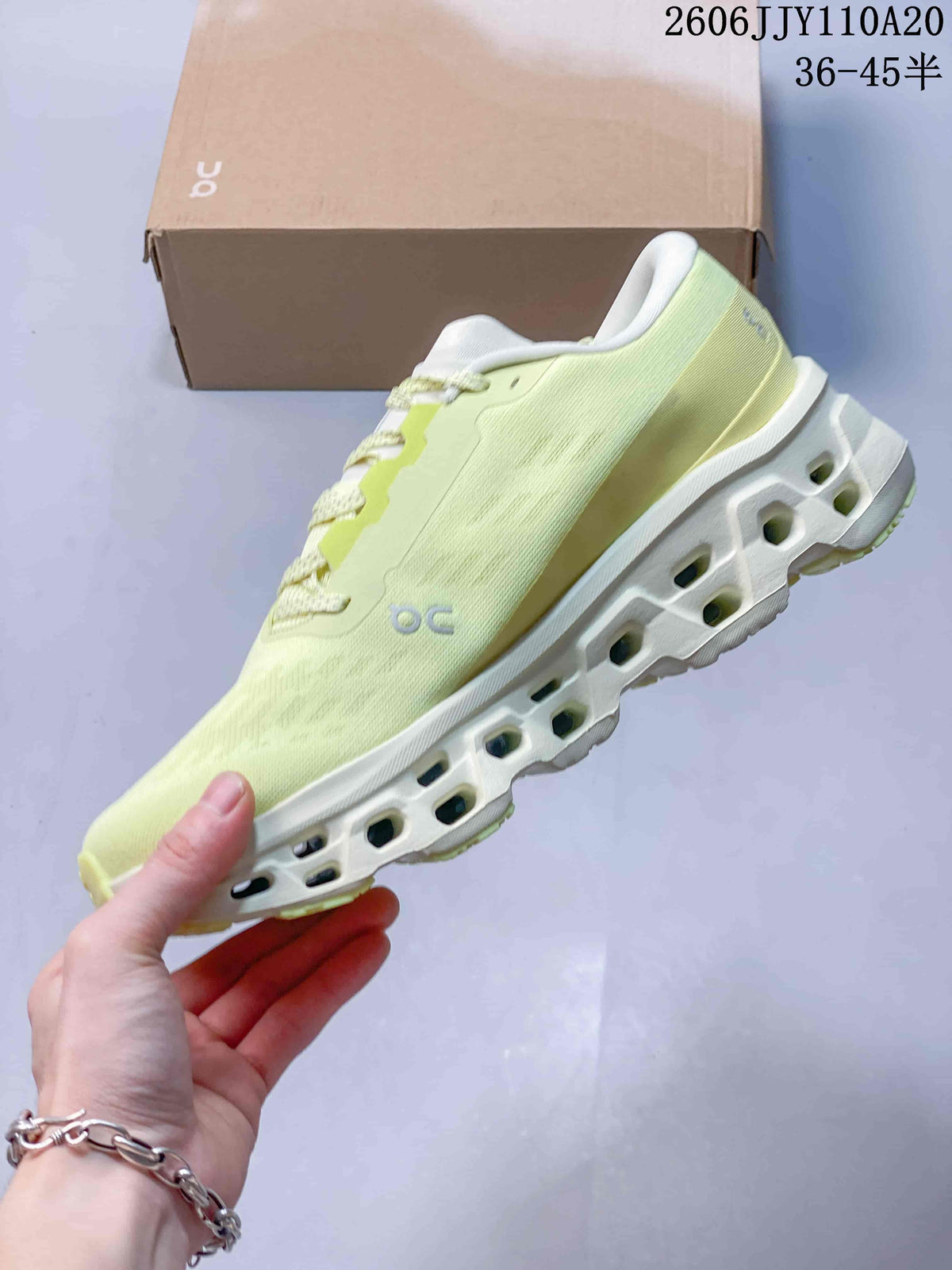 Side view of the pale yellow running shoe with a contrasting logo and sculpted sole.