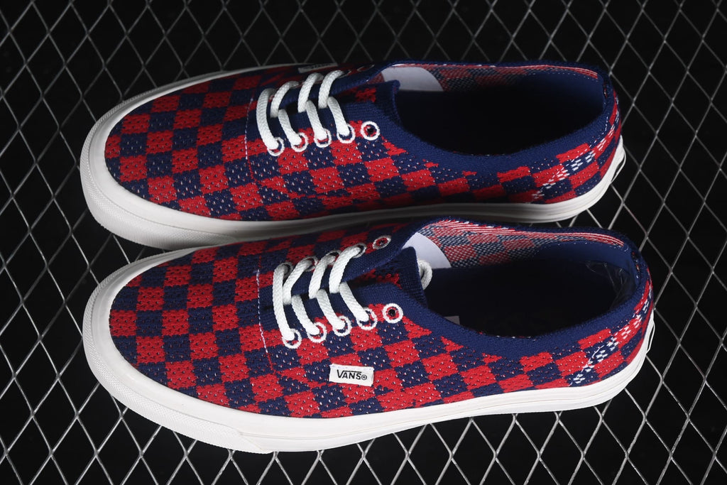 Pair of red and navy check-pattern Vans sneakers shown from an angled top view.