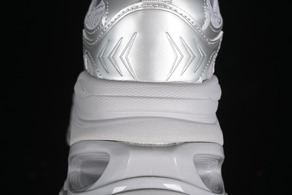 Rear close-up of the silver sneaker and its thick sculpted sole.