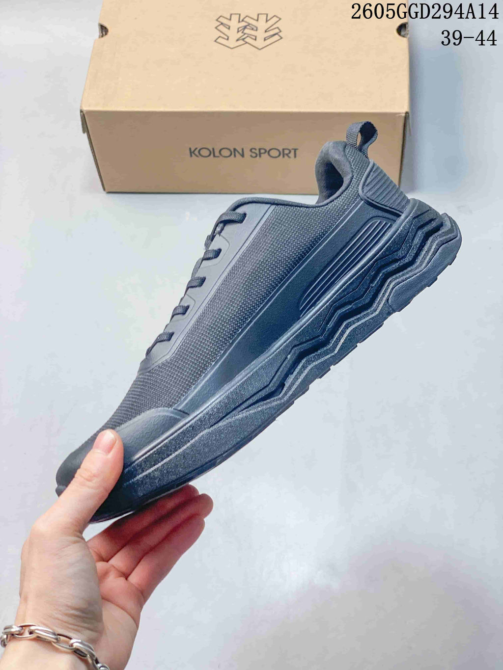 Side view of a charcoal Kolon Sport sneaker with a layered outsole