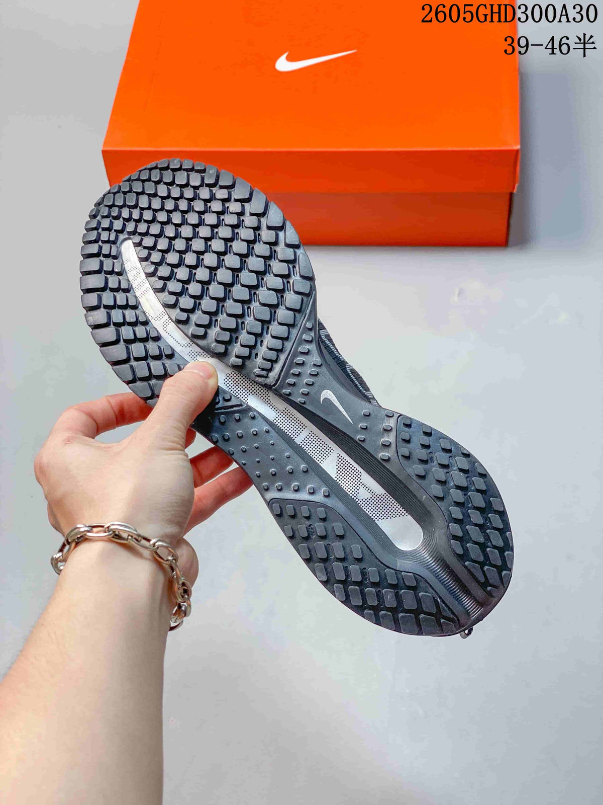 Close-up of the patterned outsole on a charcoal running shoe.