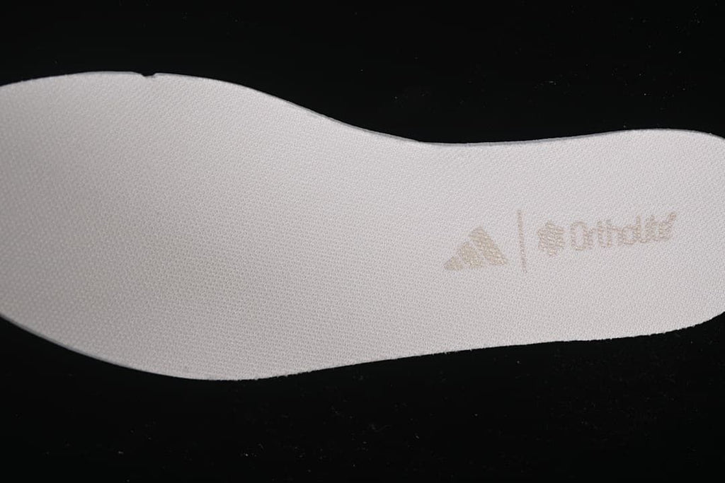 Textured surface of a white shoe-shaped insert with a faint printed logo