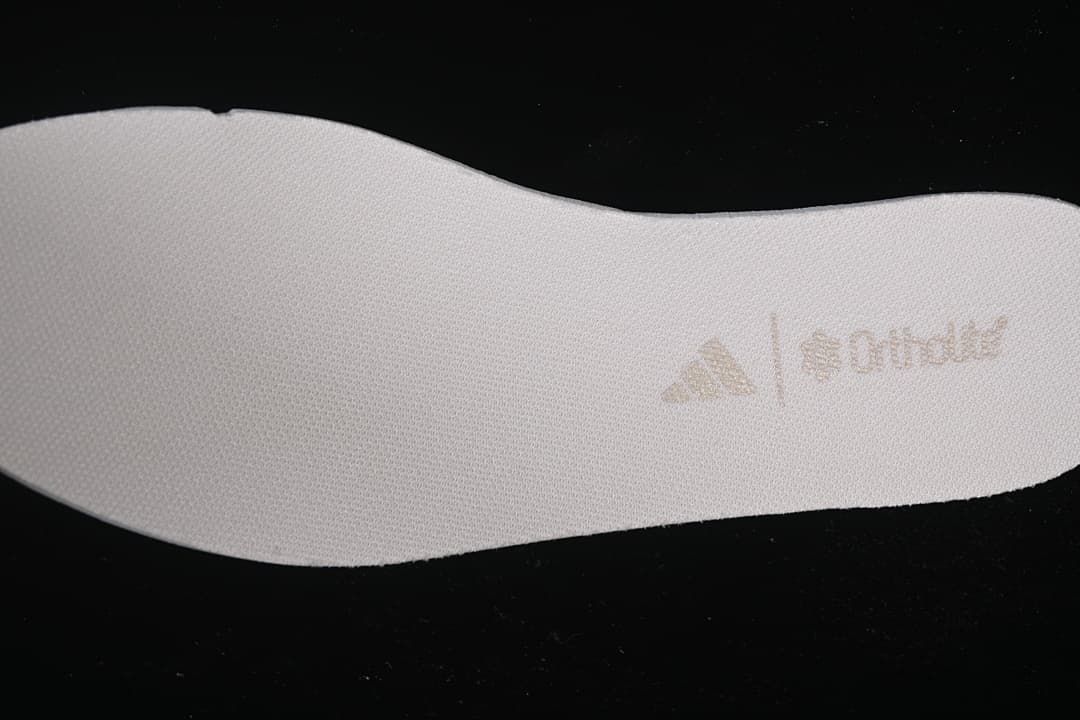 Textured surface of a white shoe-shaped insert with a faint printed logo