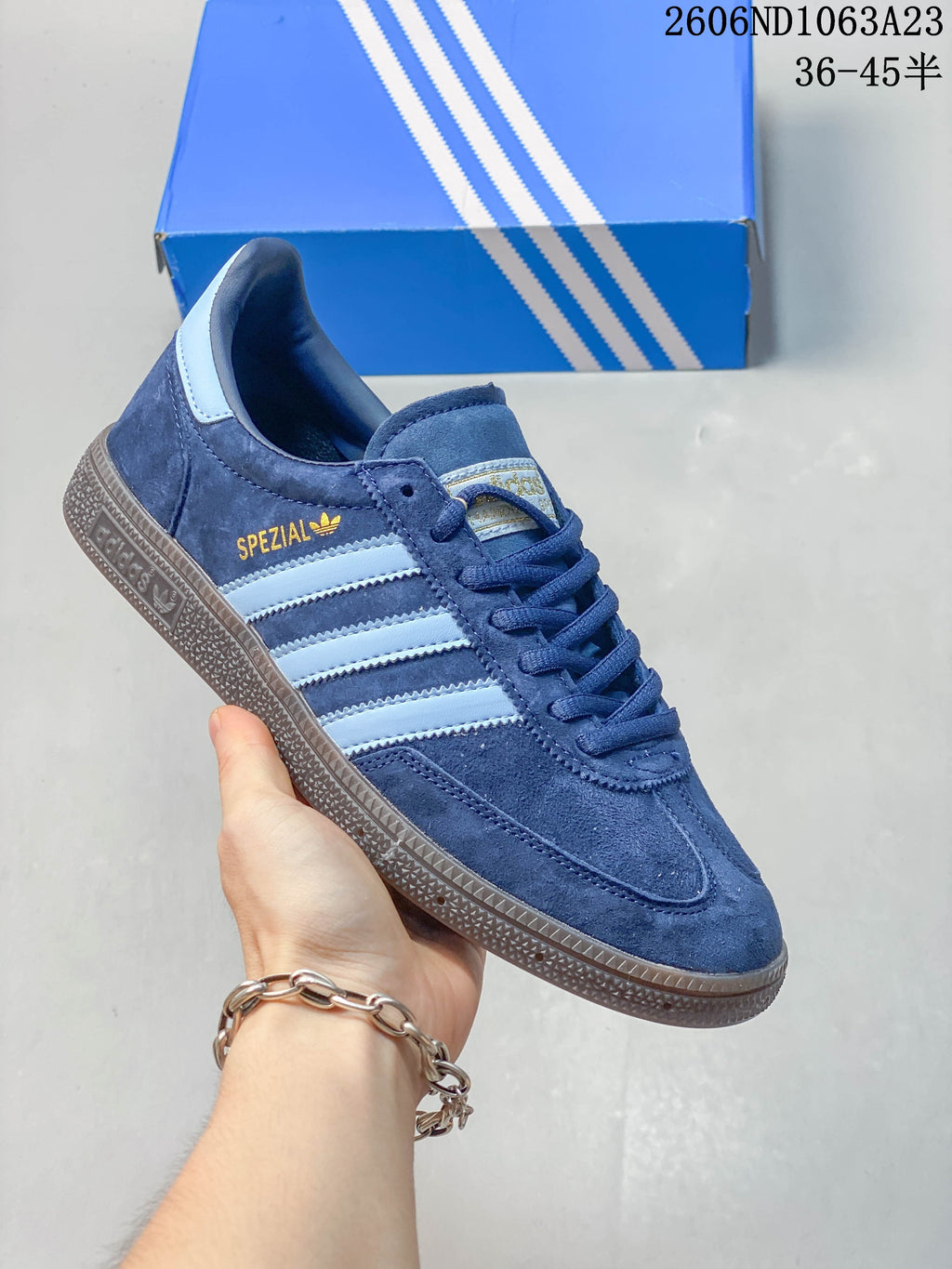 Navy Adidas Spezial low-top sneaker with pale blue stripes and a dark sole.