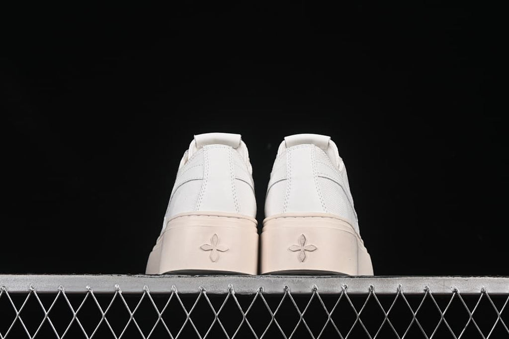 Rear view of the pair showing the heel panels and embossed sole motifs.