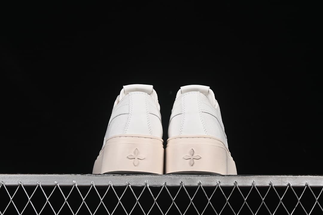 Rear view of the pair showing the heel panels and embossed sole motifs.