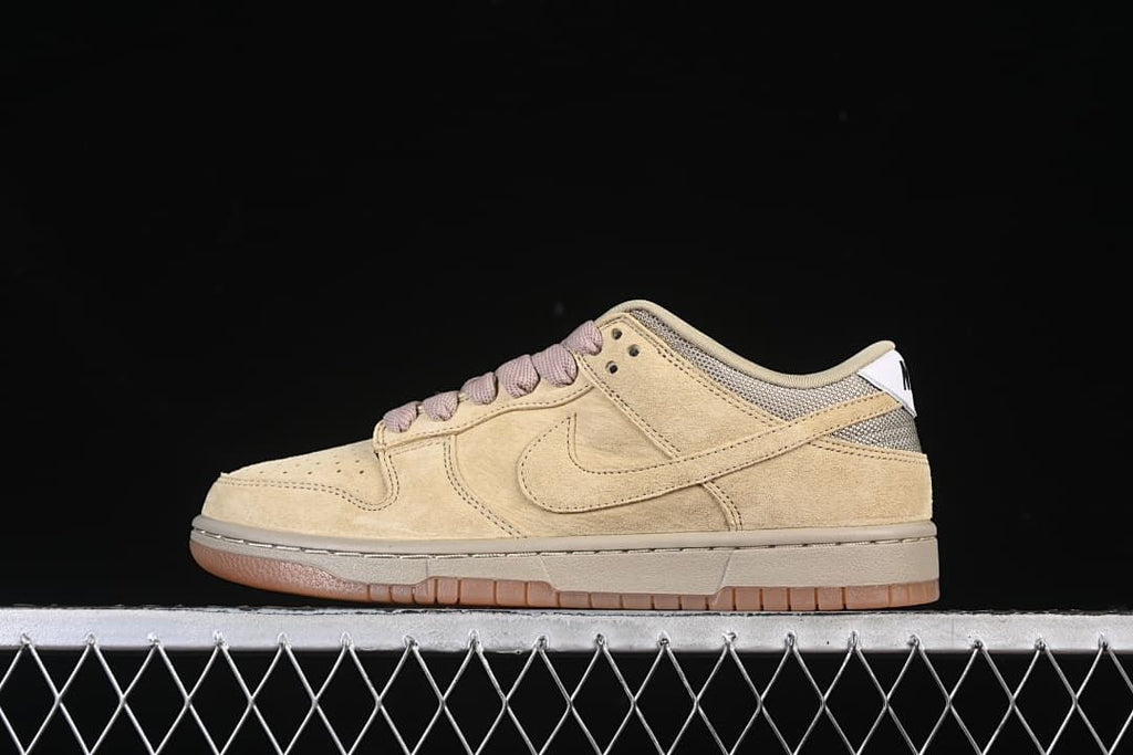 Side view of tan Nike SB Dunk Low Pro B sneakers with mauve-toned laces and gum-colored outsole
