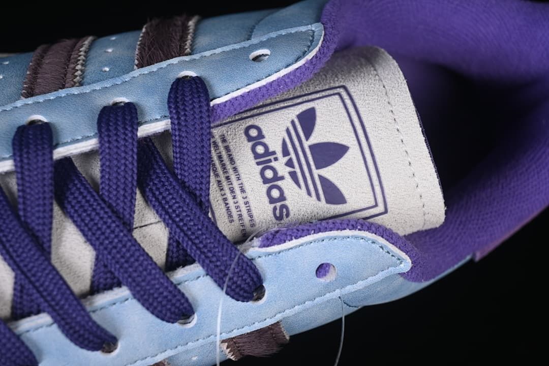 Close-up of the adidas-branded tongue and dark purple laces
