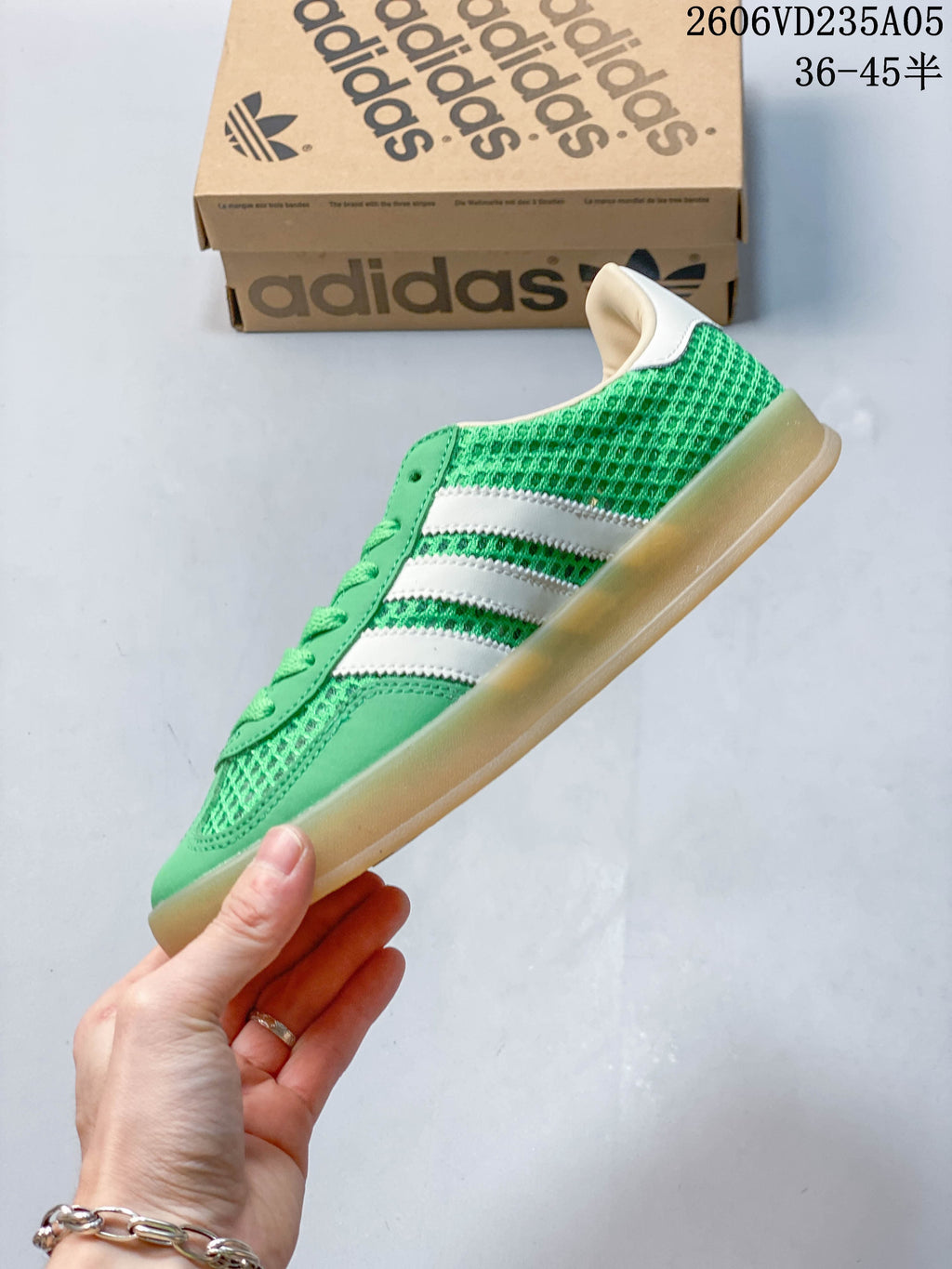Side profile of a green low-top sneaker with white stripes and a gum-colored sole.