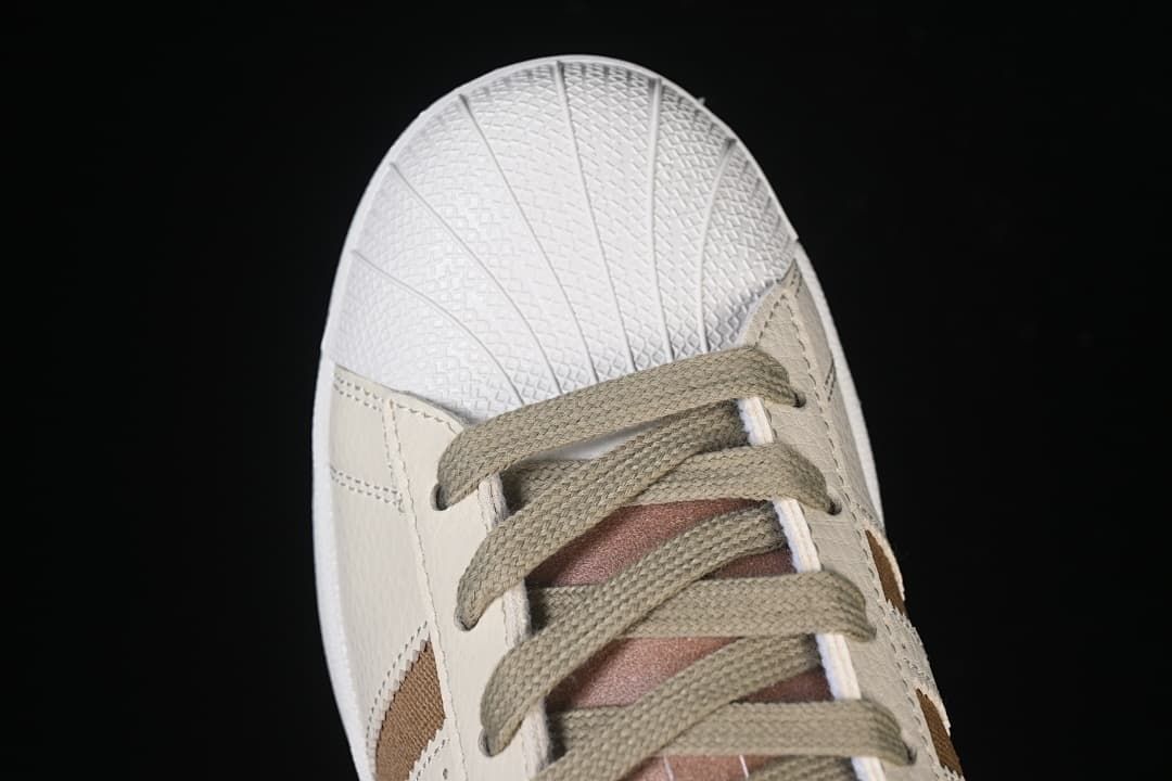 Top view of the shell toe and olive-toned laces.