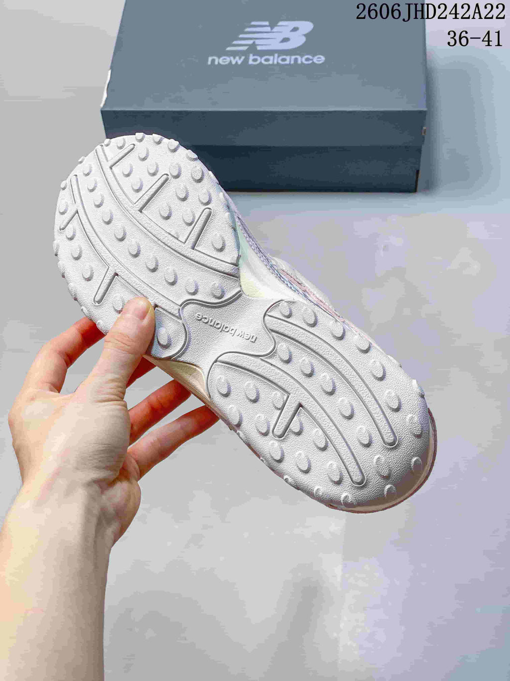 Close-up of the textured outsole on a pink and silver sneaker.