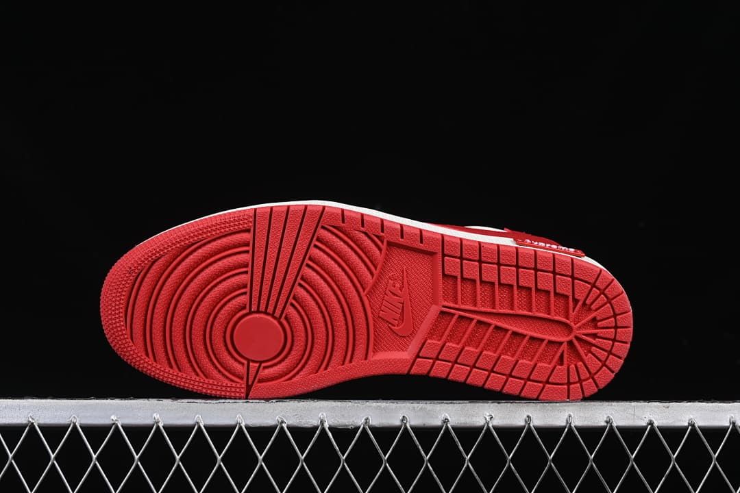 Red outsole with circular forefoot tread and patterned traction grooves.