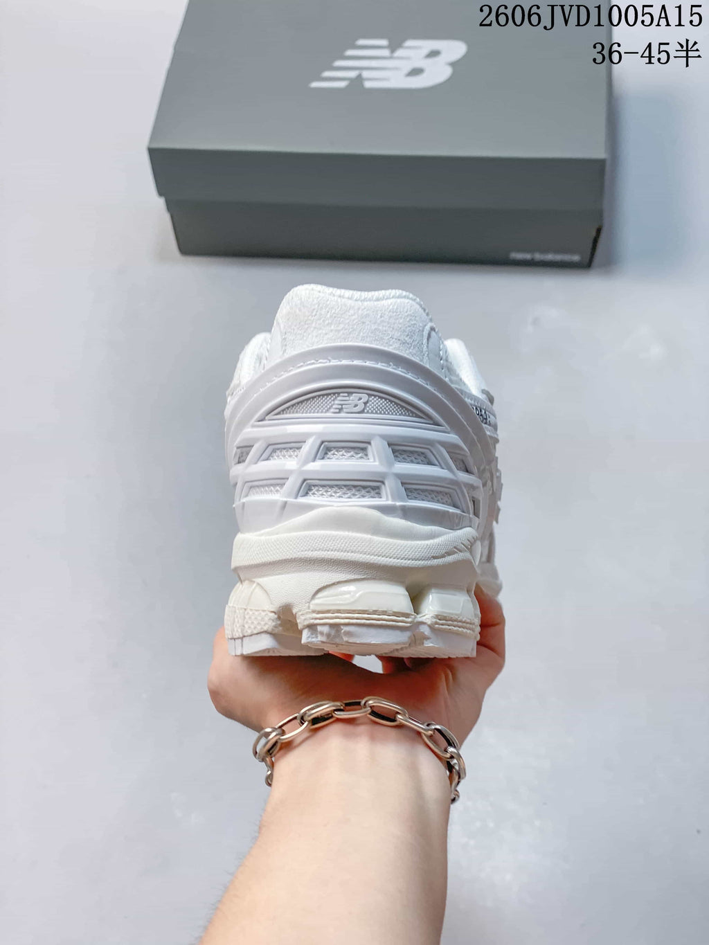 Rear view of the white sneakers showing the heel and outsole