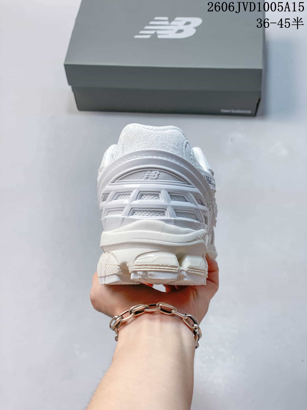 Rear view of the white sneakers showing the heel and outsole