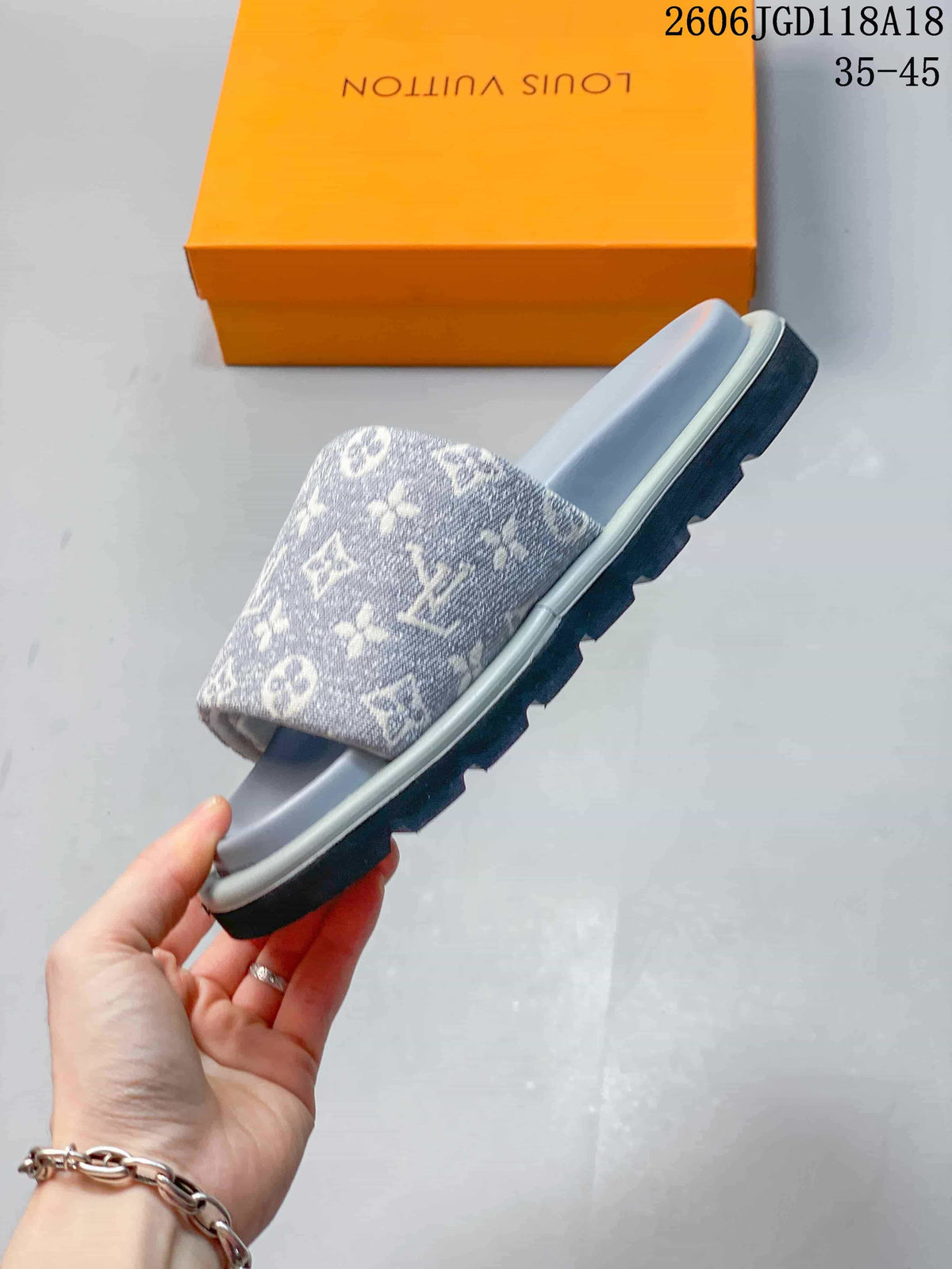 Side view of the gray patterned slide sandal with ridged outsole