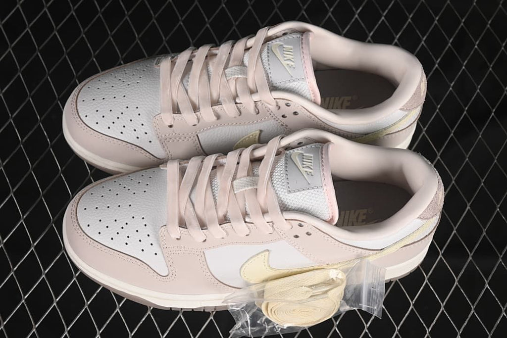 Pair of pink and white sneakers with an extra set of pale laces