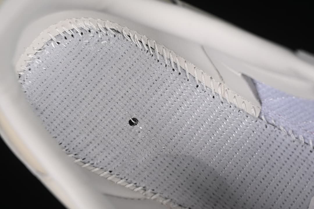 Close-up of the sneaker's perforated interior panel and stitching