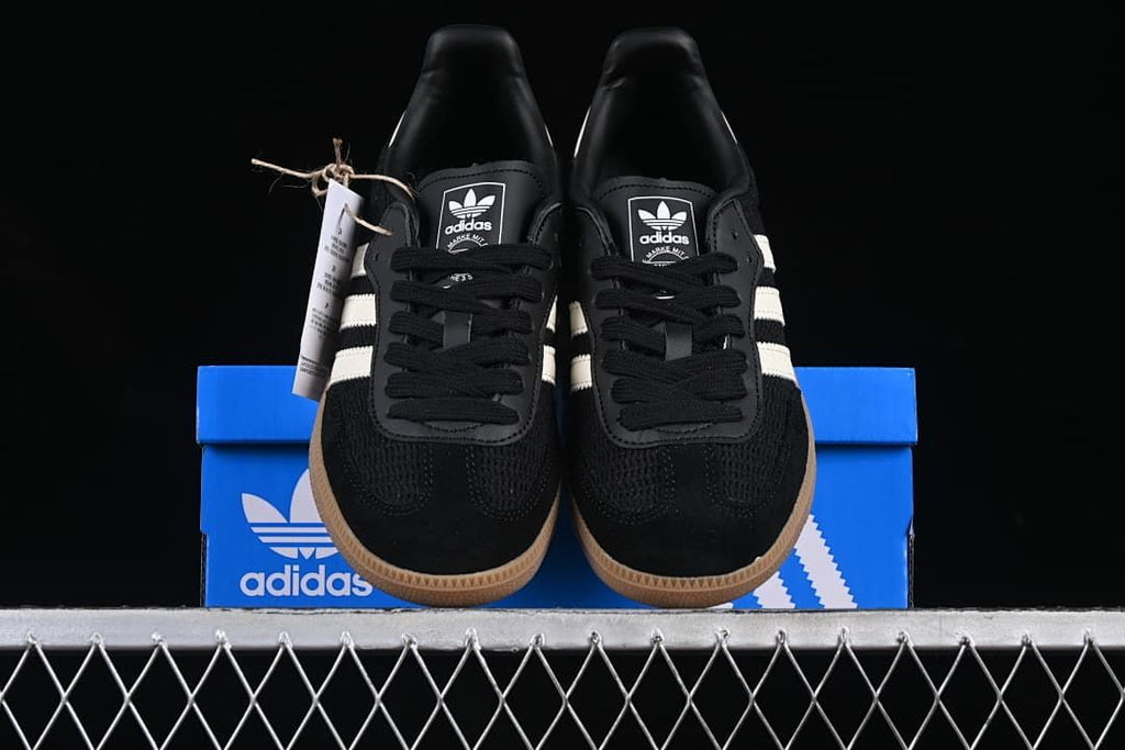 Front view of the pair of black and white Samba OG sneakers on the shoe box