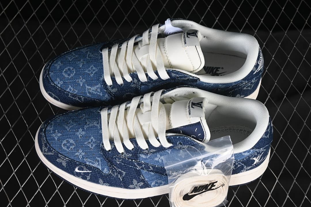 Pair of dark blue patterned low-top sneakers with white laces and visible monogram-style graphics.