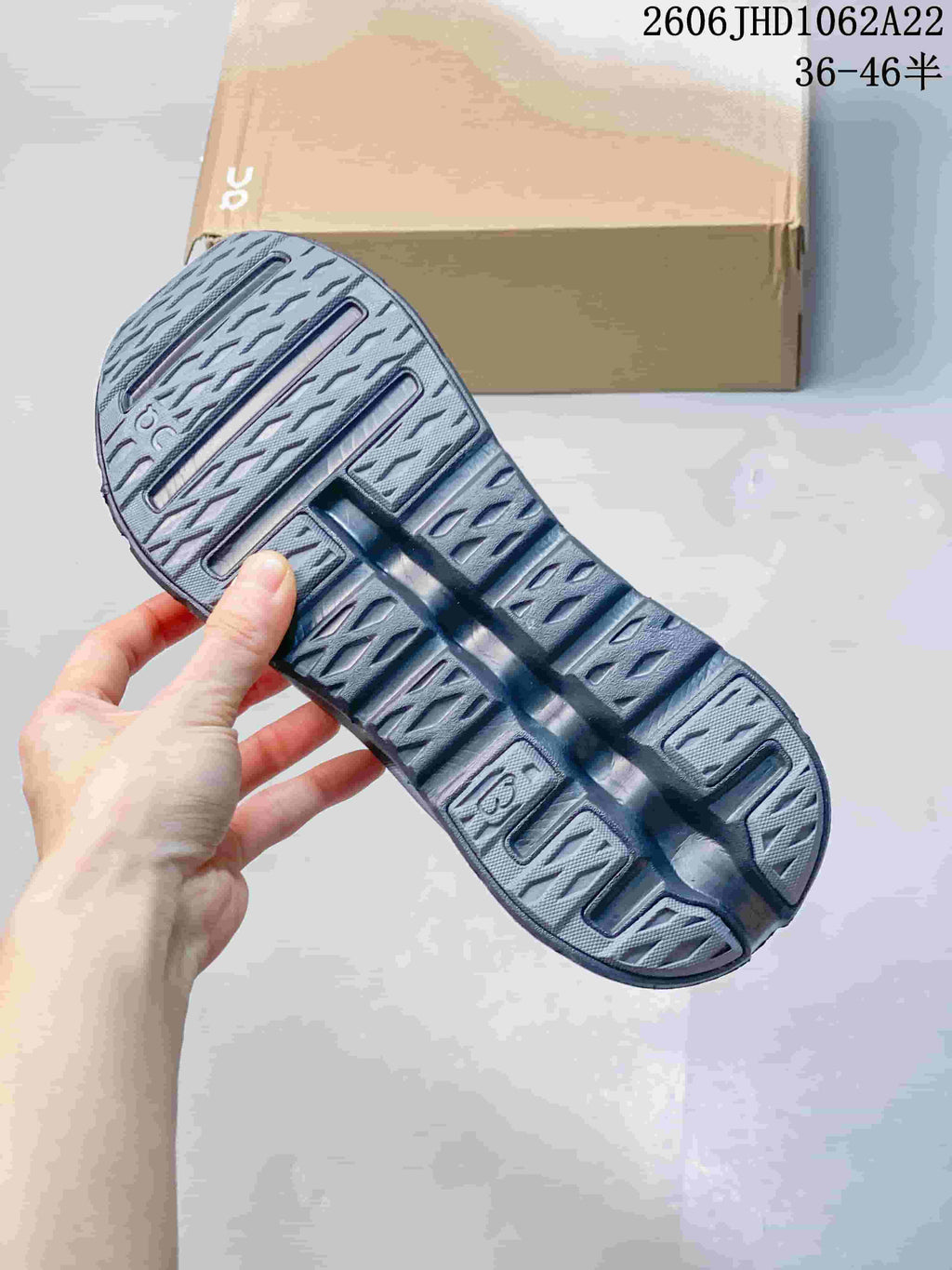 Close-up of the patterned outsole on a gray On Cloudtilt Remix sneaker.