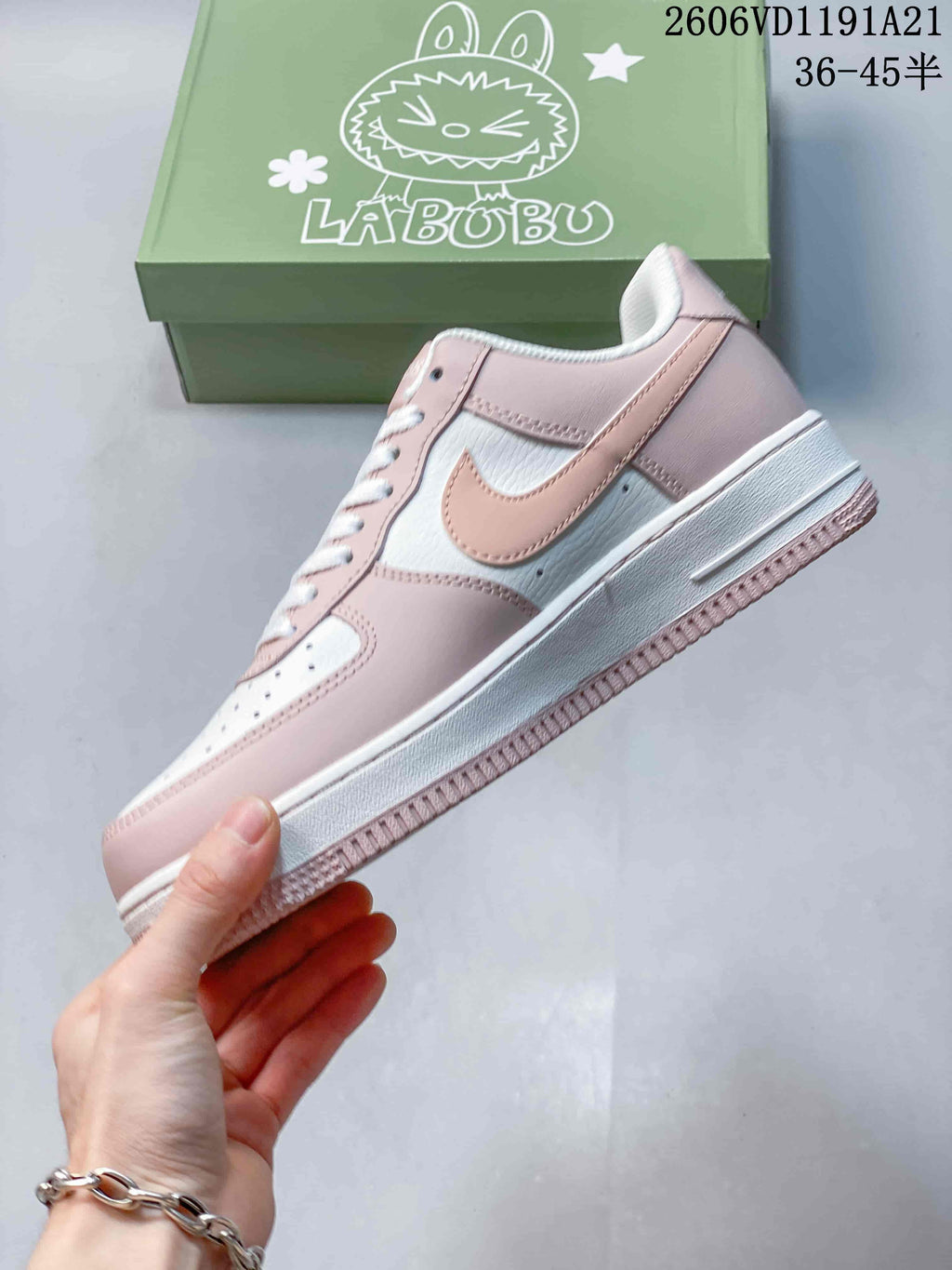 Side view of the pink and white low-top sneaker showing its overlays and themed box