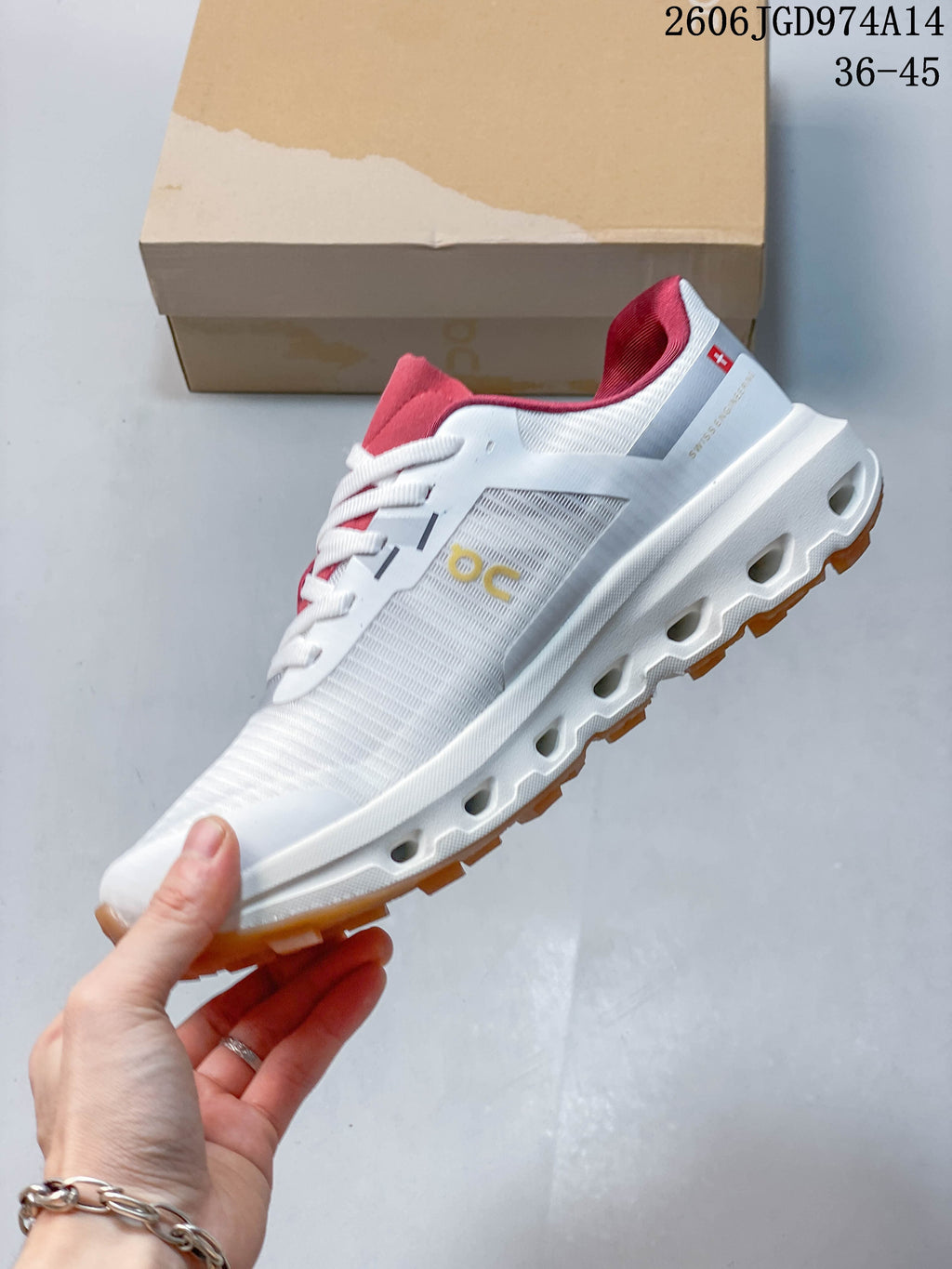 Side view of a white On Cloudvista 2 shoe showing its pink accents and lugged outsole.