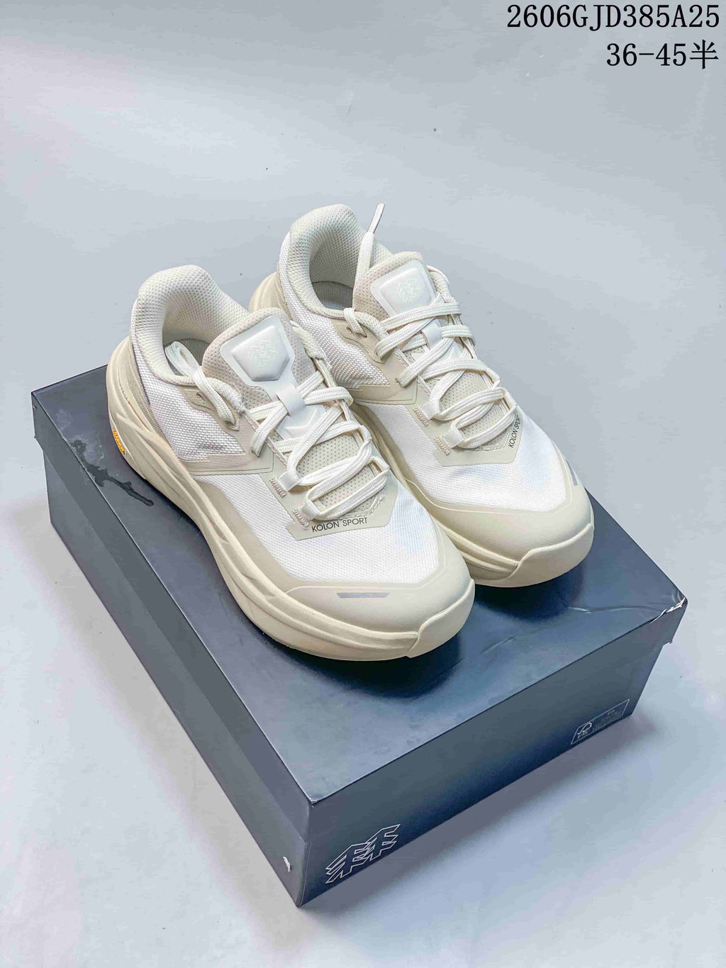Pair of off-white Kolon Sport low-top shoes on a box