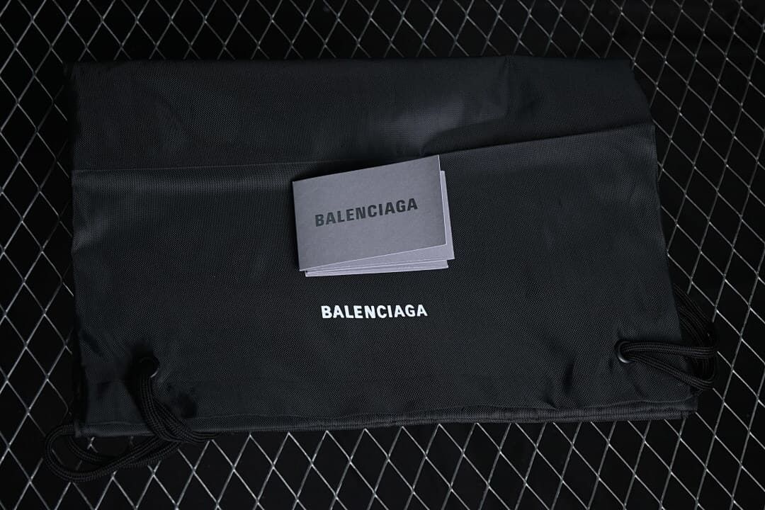 Black drawstring bag and booklet bearing Balenciaga branding.