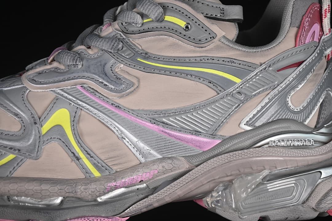 Close-up of layered beige and gray panels with pink and yellow accents.