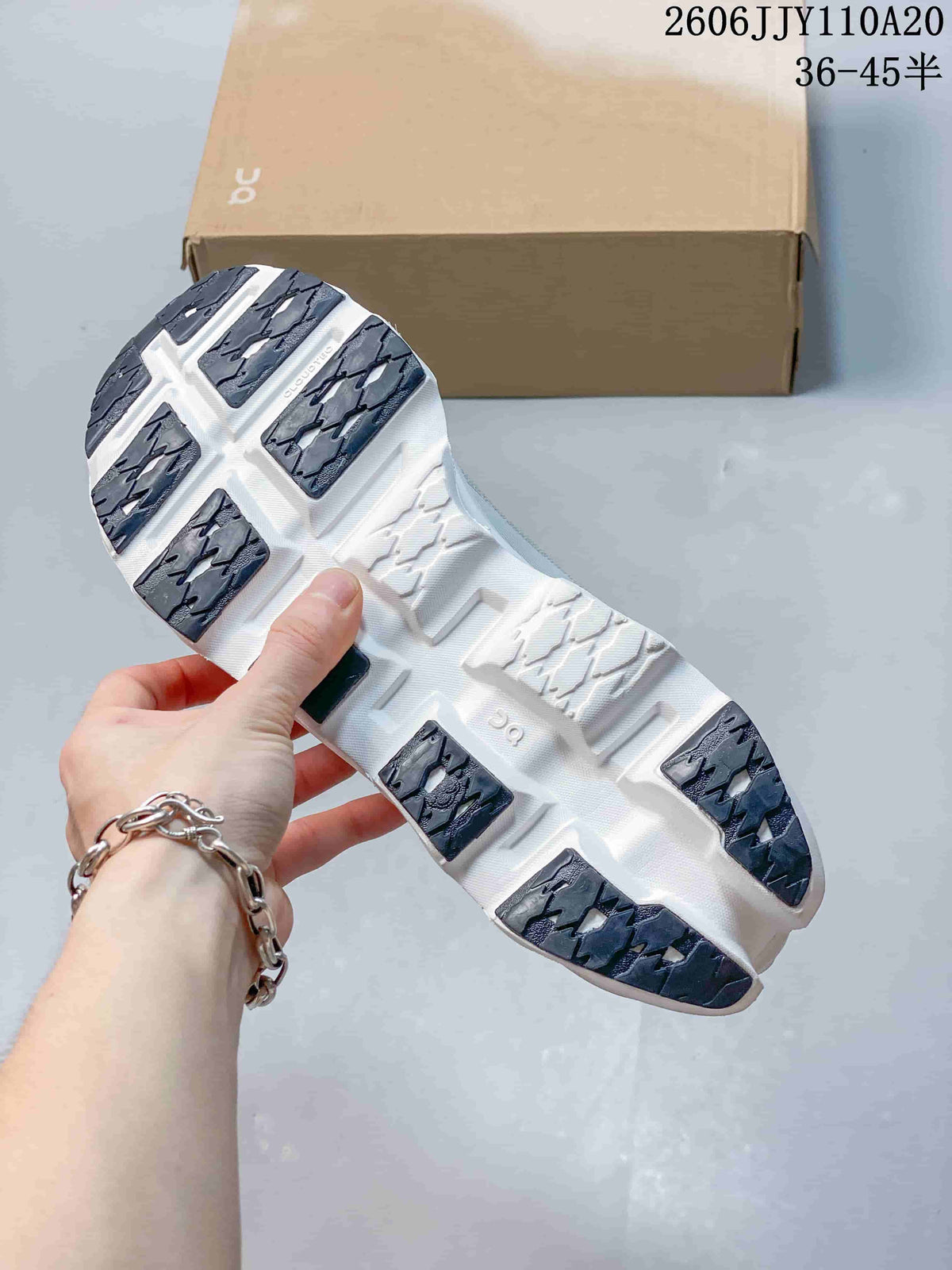 Underside of a running shoe showing white sole sections and dark tread panels