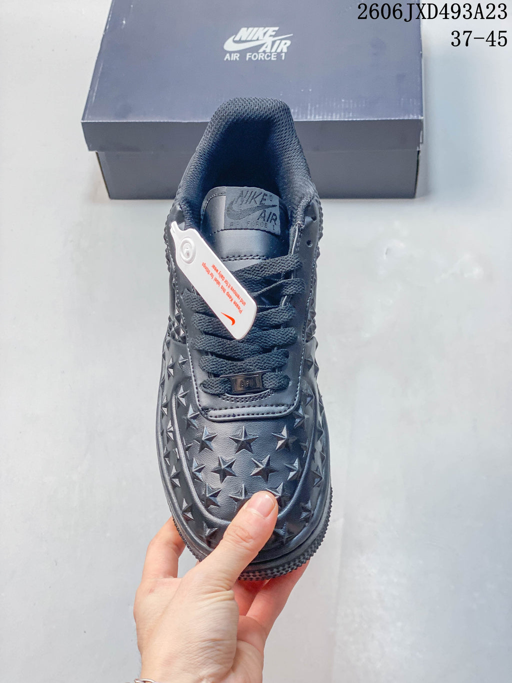 Top view of a dark lace-up sneaker with star-patterned toe panel
