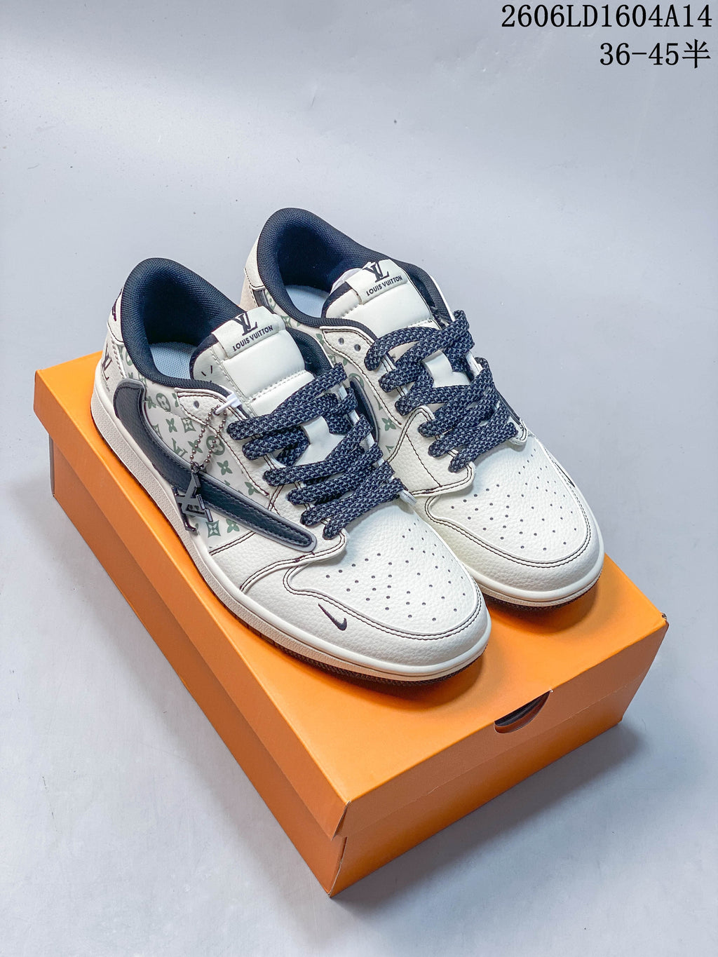 Pair of white low-top sneakers with green monogram-style graphics and navy accents