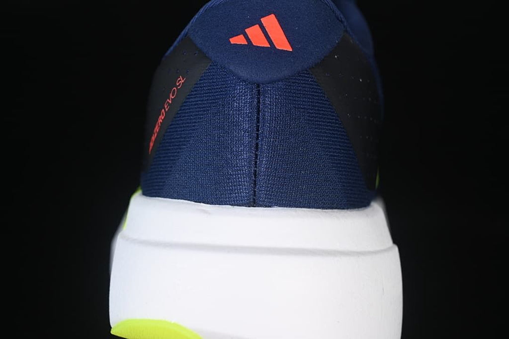 Rear view showing the navy heel, white midsole, and lime outsole accent.