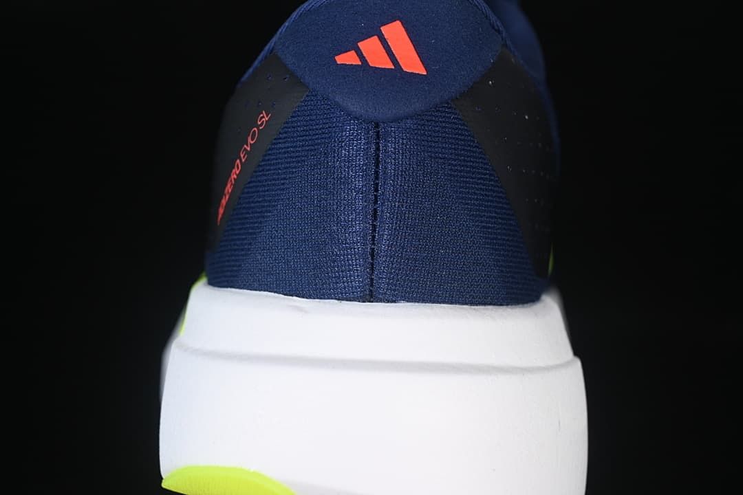Rear view showing the navy heel, white midsole, and lime outsole accent.