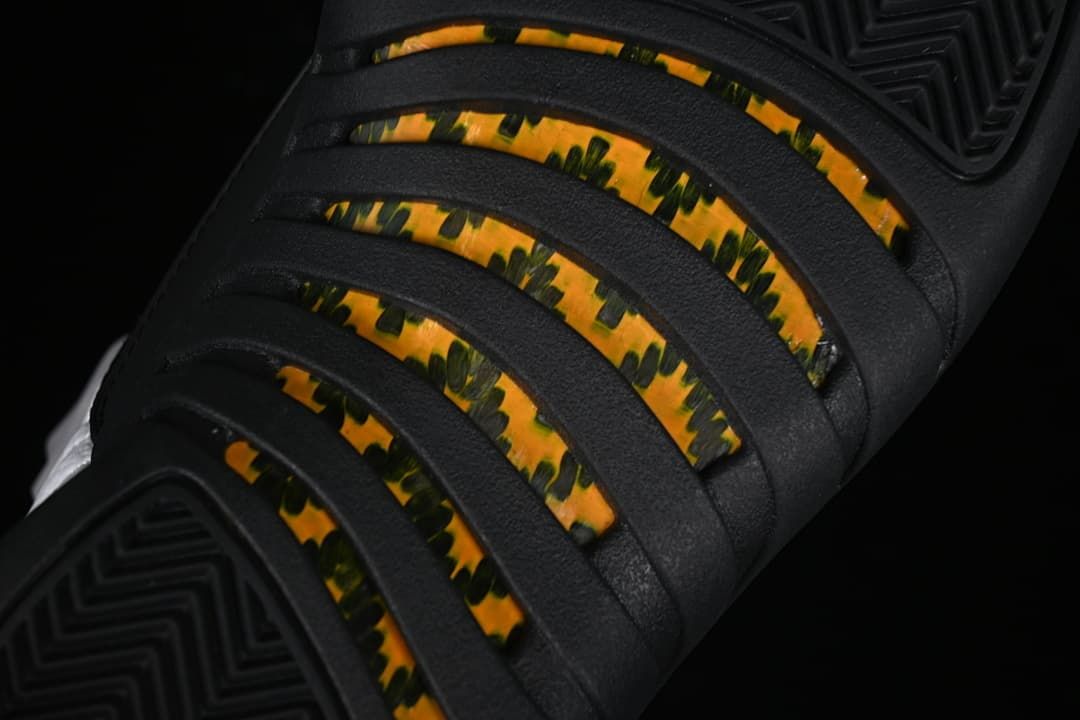 Close-up of the black outsole with yellow and dark patterned sections.