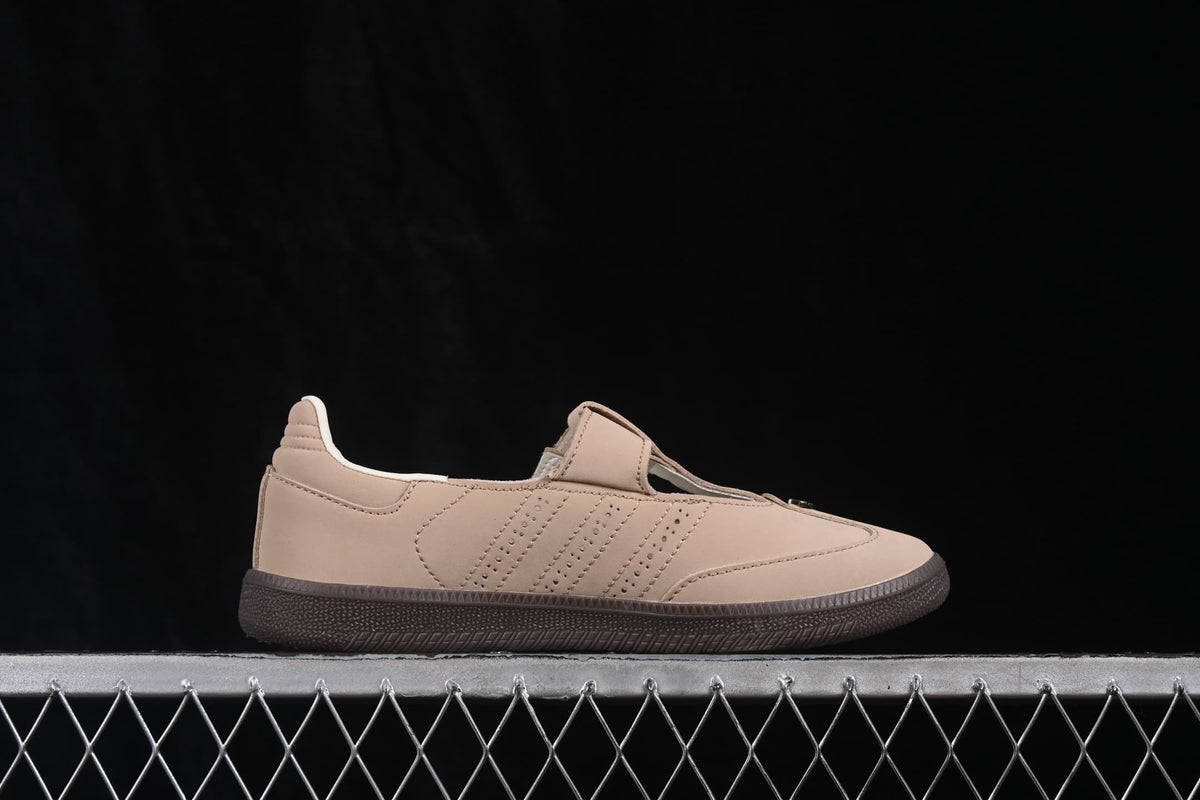 Side profile of a light beige adidas Samba Jane sneaker showing the strap upper, perforated side detailing and dark rubber outsole.