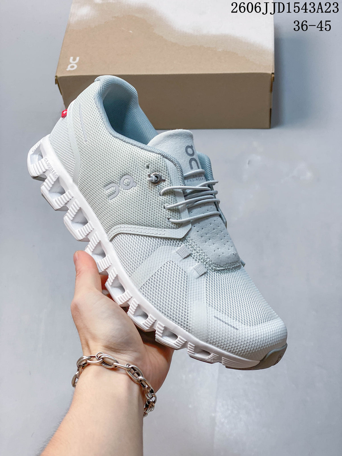 Side view of a light gray and white On Cloudtilt Remix sneaker