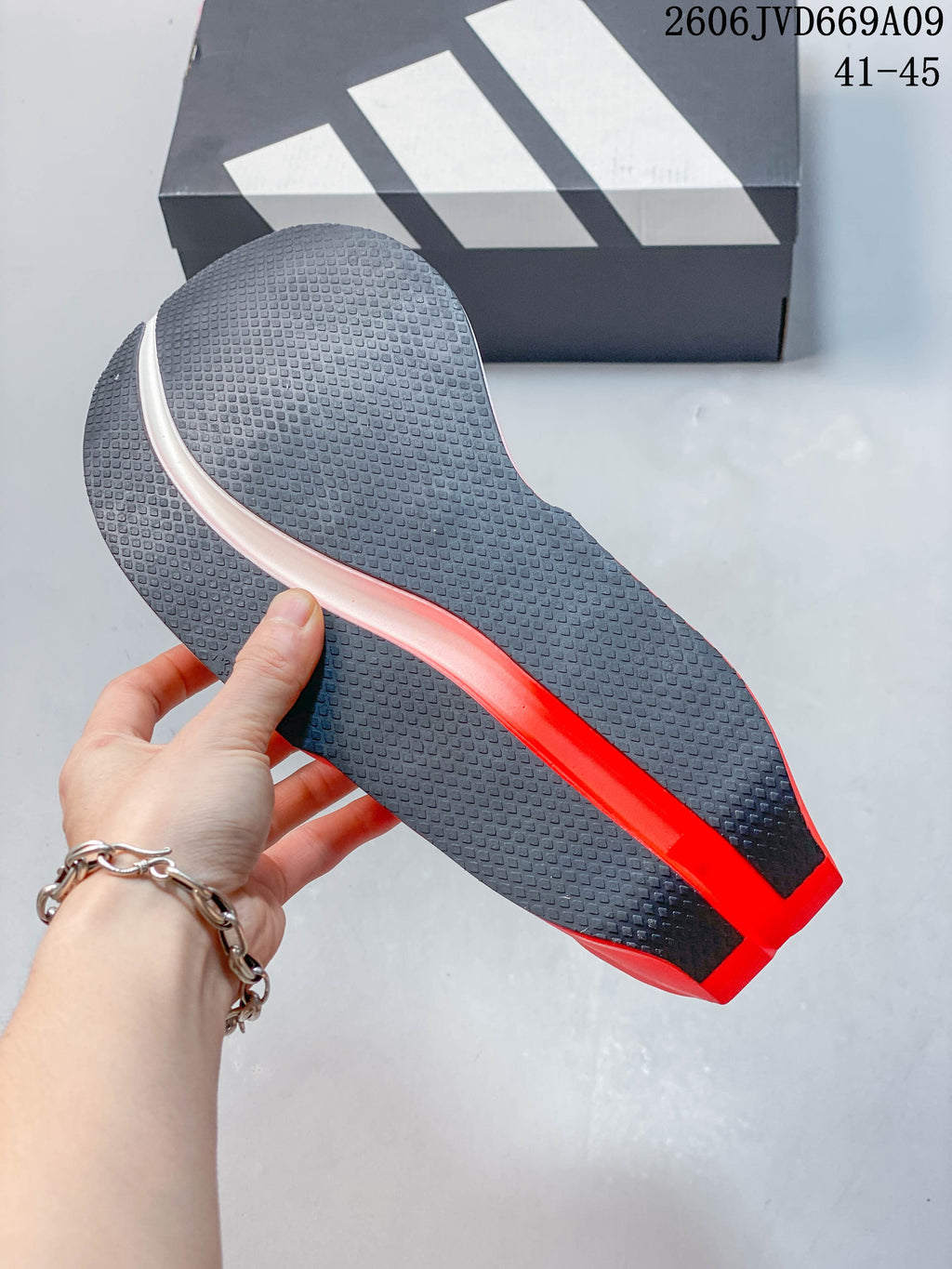 Close-up of the shoe's dark patterned outsole with a bright red central section
