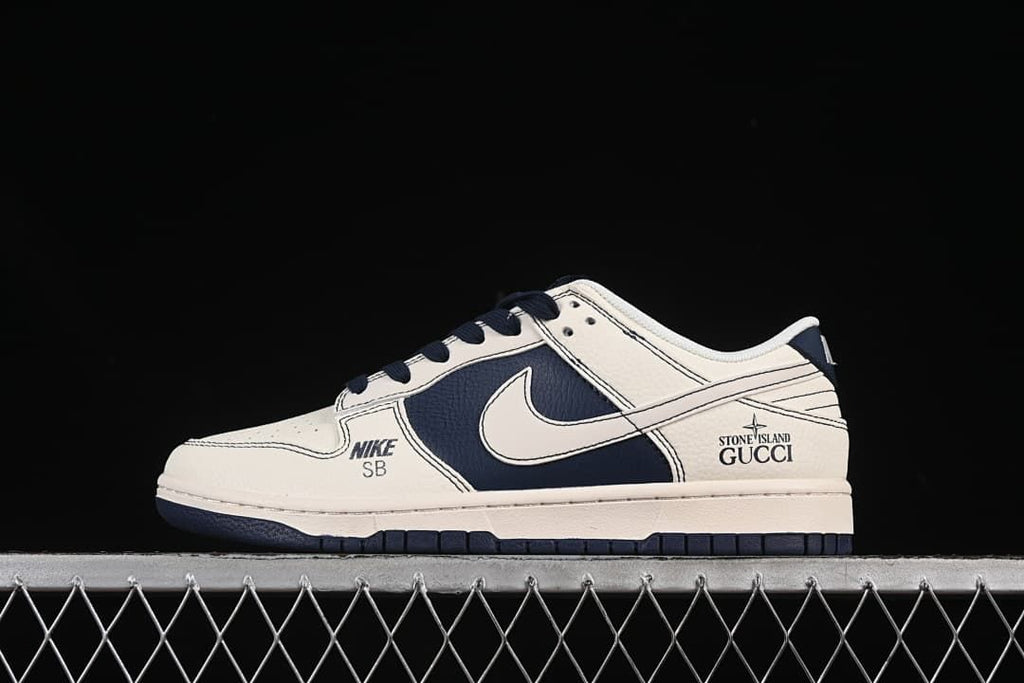 Side view of an off-white and navy Nike SB Dunk Low showing its layered panels and printed details.