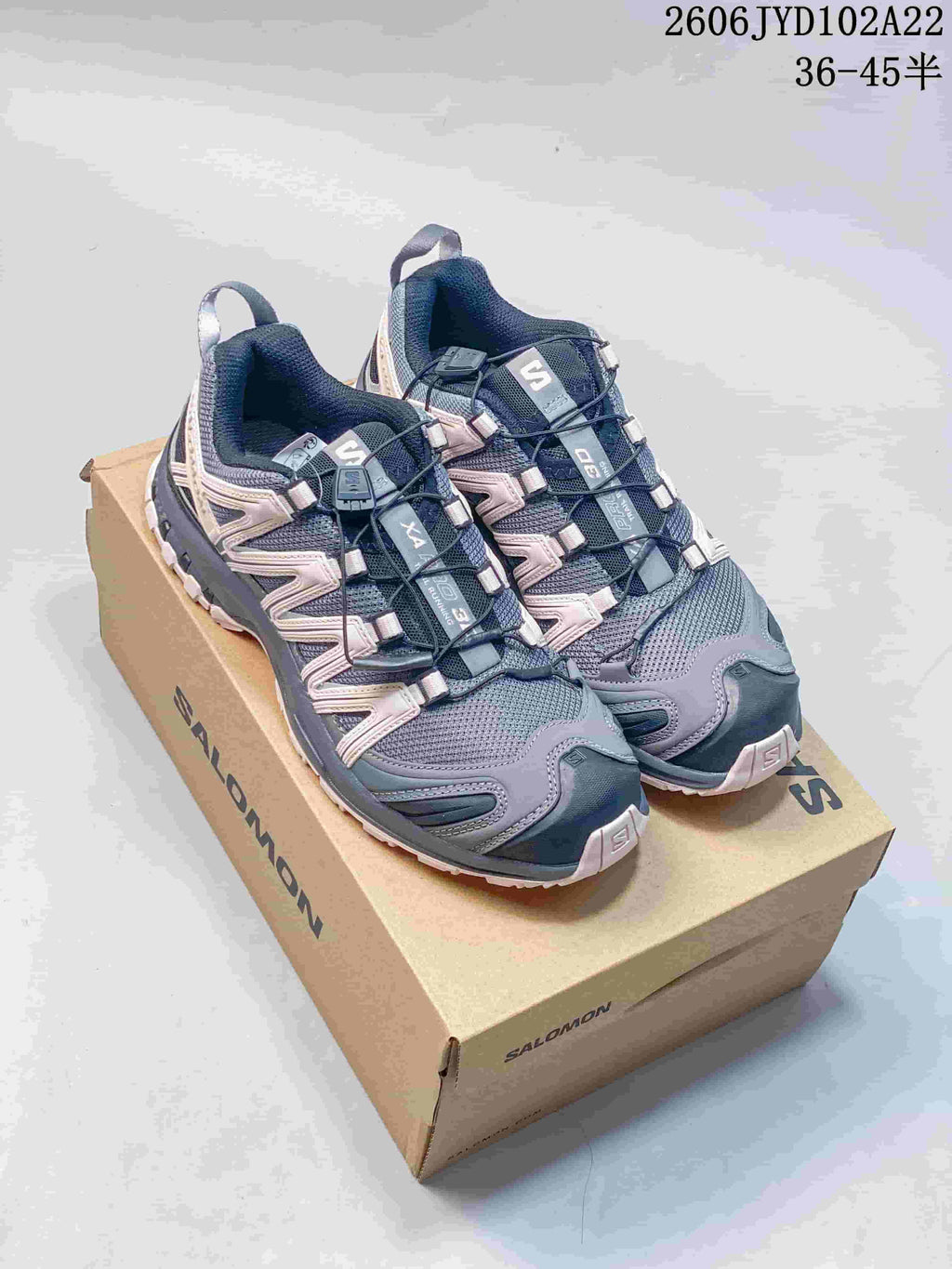 Pair of gray and pale pink Salomon XA Pro 3D shoes on a shoebox
