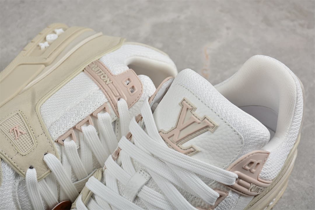 Close-up of the sneaker tongues, laces, and pale pink logo details.