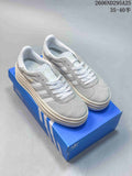 Pair of grey Adidas Gazelle Bold W platform sneakers with white laces and three-stripe details on a blue box