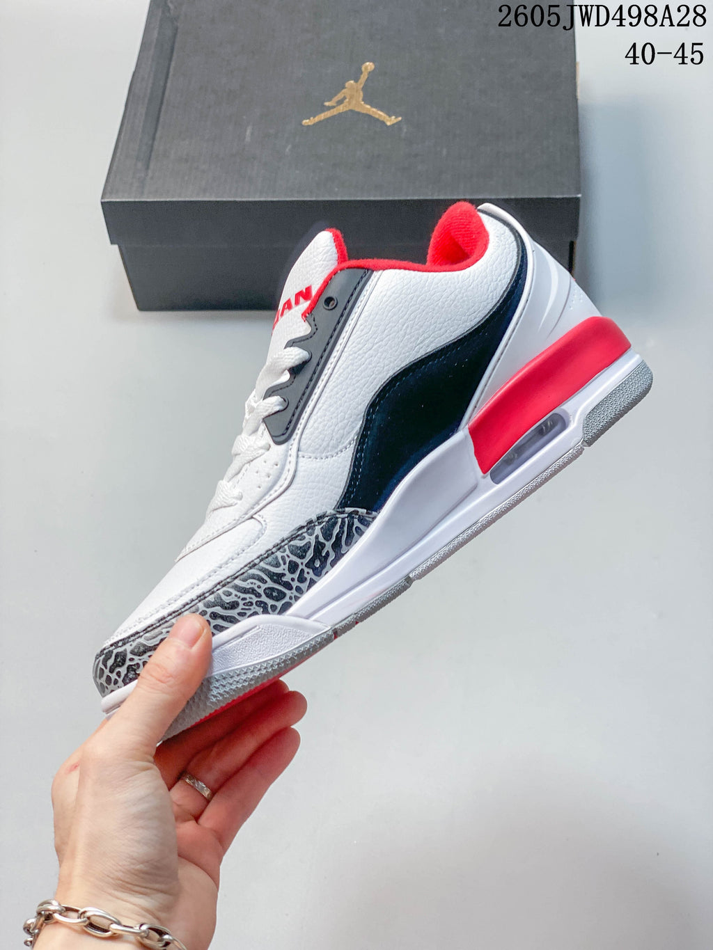 Side view of a white low-top Jordan sneaker with red and navy accents and elephant-print toe trim