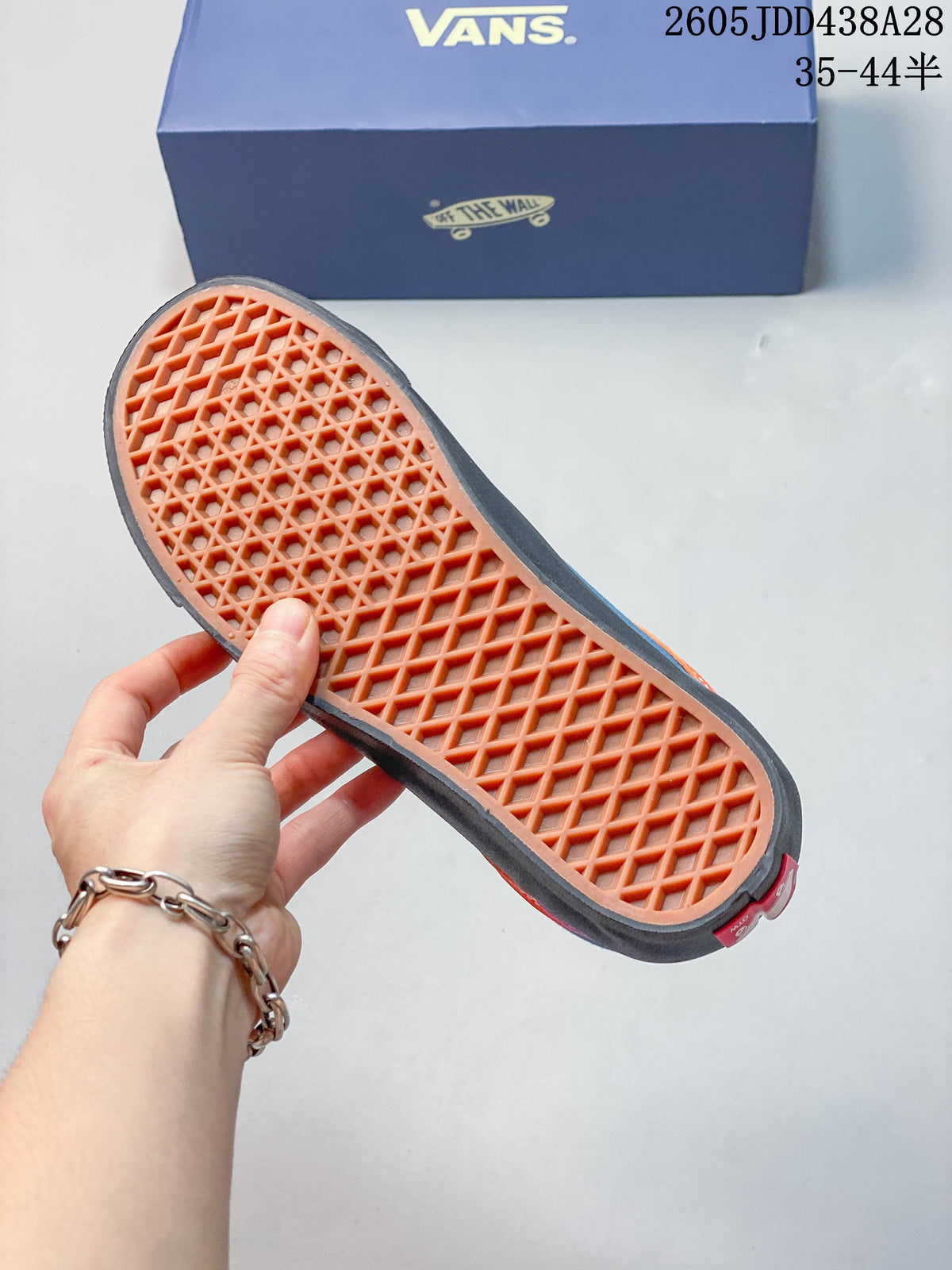 Close-up of the orange waffle-pattern outsole on a Vans sneaker